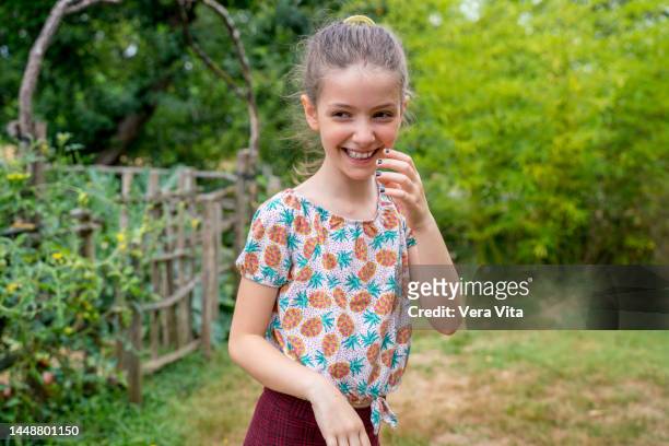 portrait of blonde little girl smiling with shyness in summer casual clothes on the garden in holidays. - 8 girls no cup stock-fotos und bilder