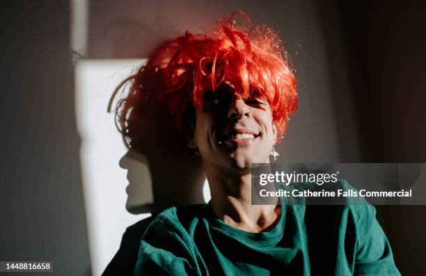 playful image of a smiling man wearing a bright red wig - choker necklace stock pictures, royalty-free photos & images