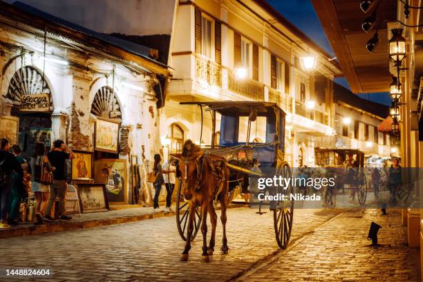 spanish colonial street and horse drawn carriage in vigan, philippines - spanish-colonial-architecture stock pictures, royalty-free photos & images