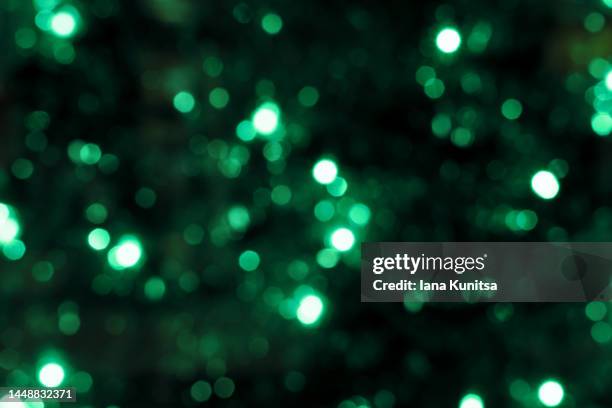 christmas lights. festive new year blurred green and black background. beautiful sparkling backdrop, texture. bokeh. copy space. xmas. - christmas background green stock-fotos und bilder