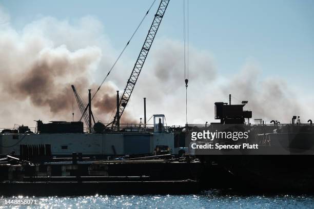 Smoke bellows from a building as firefighters and other emergency personnel work to control a large fire in the Brooklyn neighborhood of Red Hook on...