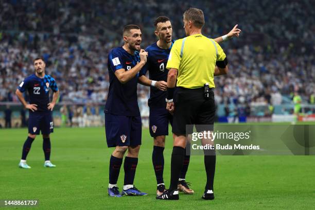 Mateo Kovacic and Ivan Perisic of Croatia protest to Referee Daniele Orsato after the penalty decision following the foul of Dominik Livakovic of...
