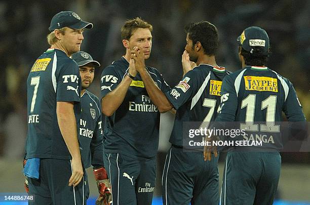 Deccan Chargers bowler Dale Steyn celebrates with teammates after taking the wicket of unseen Royal Challengers Bangalore batsman Zaheer Khan during...