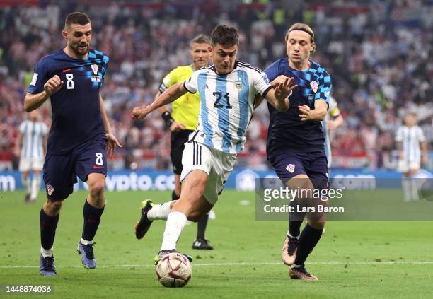 Paulo Dybala of Argentina competes for the ball against Mateo Kovacic and Lovro Majer of Croatia during the FIFA World Cup Qatar 2022 semi final...