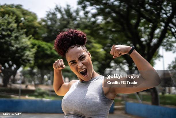 porträt einer jungen frau, die auf einem sportplatz feiert - competitive advantage stock-fotos und bilder