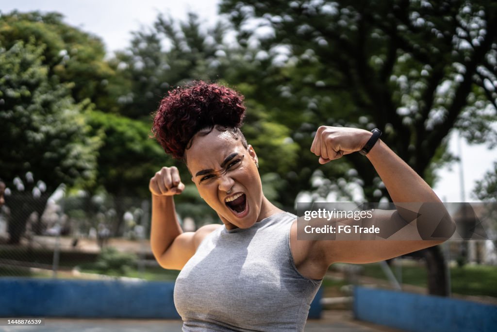 Portrait of a young woman celebrating at a sports court
