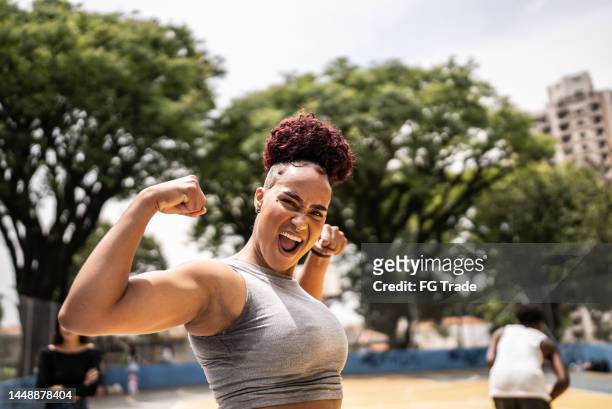portrait of a young woman celebrating at a sports court - beating adversity stock pictures, royalty-free photos & images