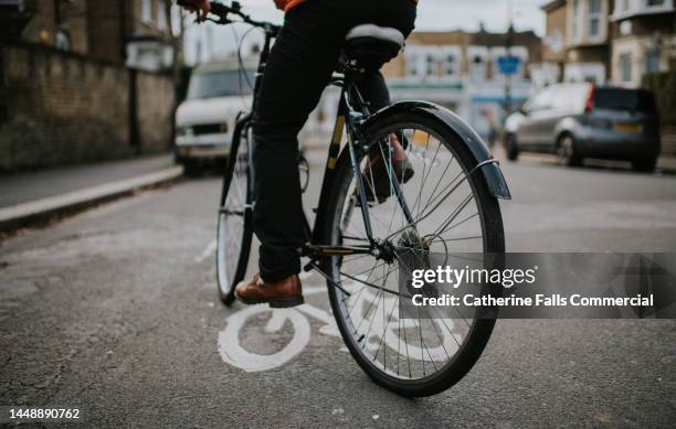 a man rides a bike in a town - rush hour stock pictures, royalty-free photos & images