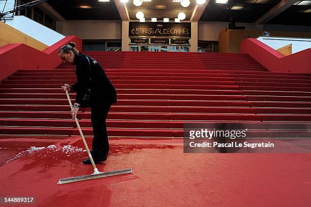 Staff sweep water from the red carpet following torrential rain priior to the "Amour" Premiere during the 65th Annual Cannes Film Festival at Palais...