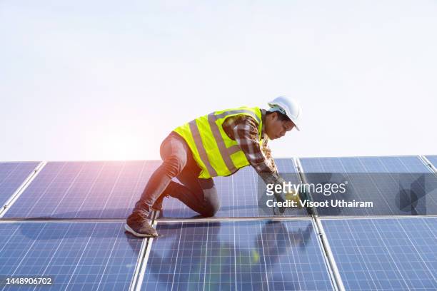 engineer installing solar photovoltaic panel system using screwdriver. - consultation lake fotografías e imágenes de stock