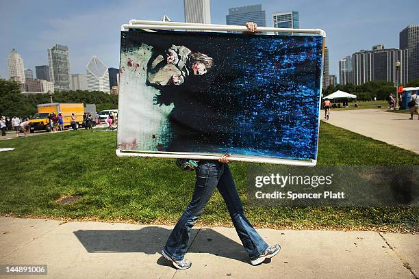 Female protester carries a painting that is the likeness of a photo made by Getty Images photographer Chris Hondros in Iraq in 2005 that shows an...