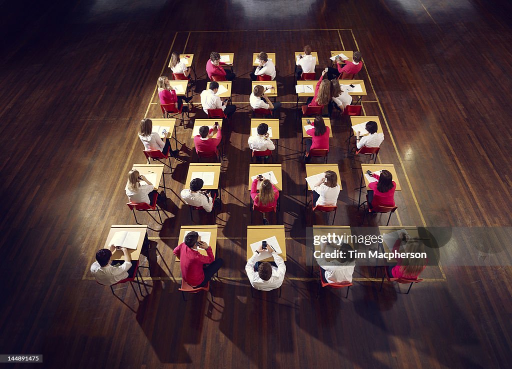 Teenagers use mobile phones in exam