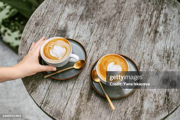 two cappuccino cups with latte art on a wooden table - cappuccino stock pictures, royalty-free photos & images