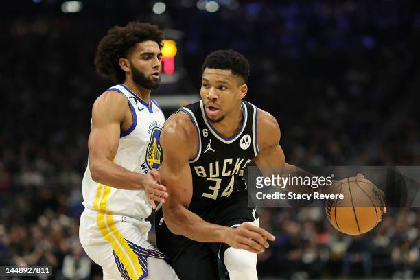 Giannis Antetokounmpo of the Milwaukee Bucks is defended by Anthony Lamb of the Golden State Warriors during the first half of a game at Fiserv Forum...