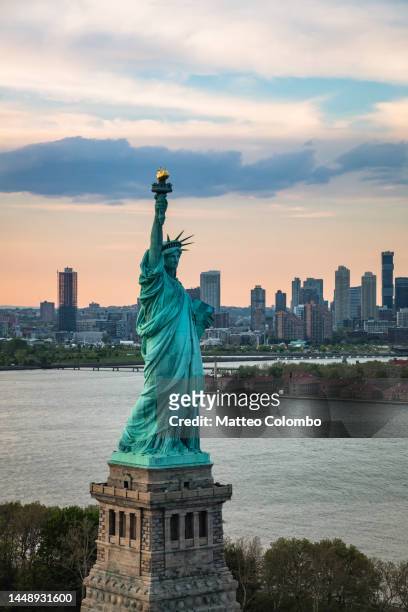 aerial of the statue of liberty at sunset, new york city, usa - liberty eiland stockfoto's en -beelden