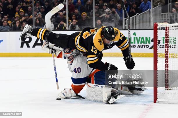 Charlie Coyle of the Boston Bruins collides with goalie Semyon Varlamov of the New York Islanders during an overtime shootout at the TD Garden on...