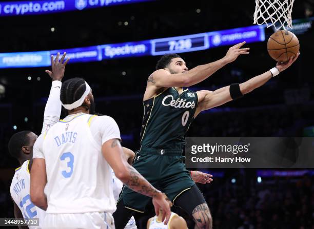 Jayson Tatum of the Boston Celtics cuts to the basket for a layup past Kendrick Nunn and Anthony Davis of the Los Angeles Lakers during the first...