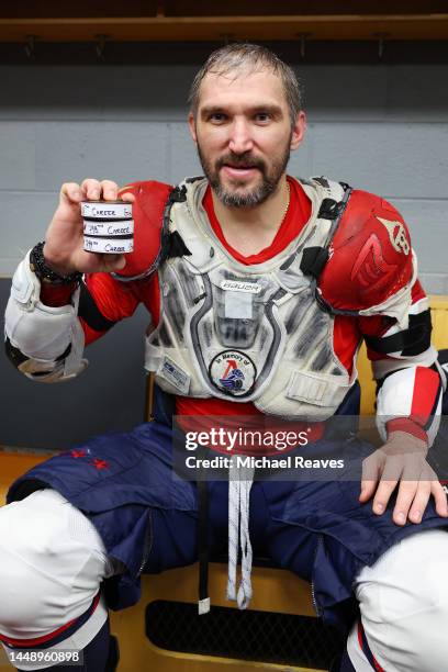 Alex Ovechkin of the Washington Capitals poses with the pucks from his 798th, 799th and 800th career goal after the game at United Center on December...