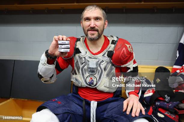Alex Ovechkin of the Washington Capitals poses with the pucks from his 798th, 799th and 800th career goal after the game at United Center on December...