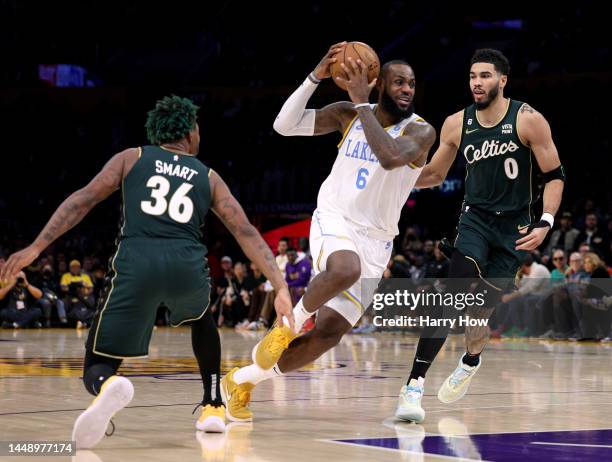 LeBron James of the Los Angeles Lakers drives between Jayson Tatum and Marcus Smart of the Boston Celtics during a 122-118 loss to the Celtics at...