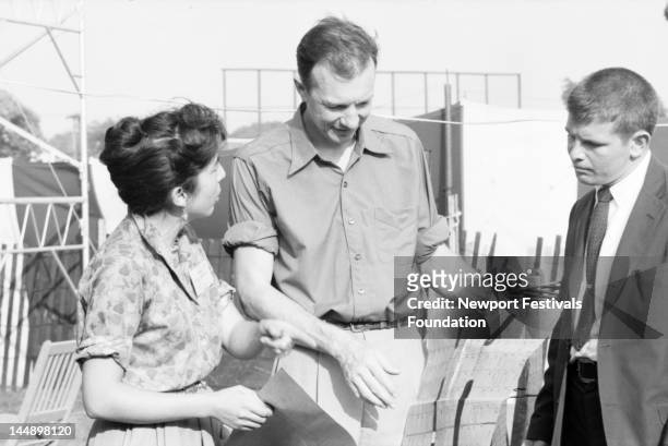 Wife and partner Toshi Seeger , folk musician and activist Pete Seeger , and a friend consult a festival program backstage at the Newport Folk...