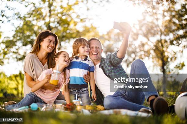 glückliche familie, die ein selfie mit handy beim picknick in der natur macht. - boy taking picture in forest stock-fotos und bilder