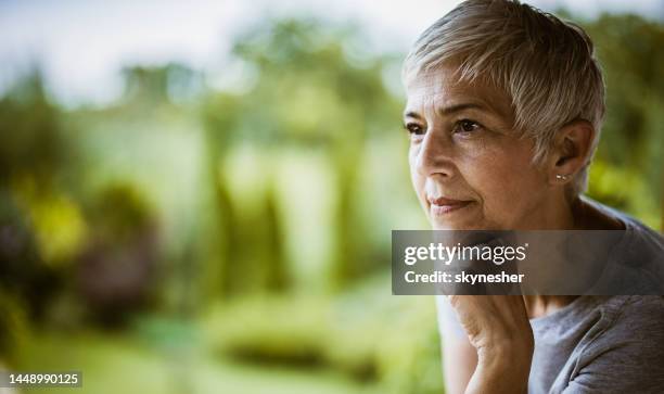 mujer mayor soñando despierta en la naturaleza. - woman day dreaming fotografías e imágenes de stock