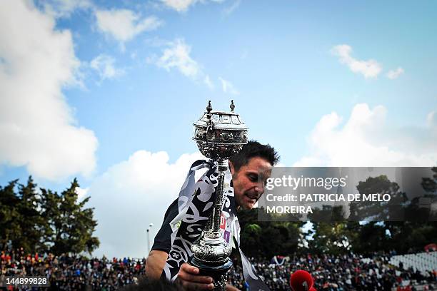 Academica's forward Mario Tomas "Marinho" holds the trophy as he celebrates his team's victory over Sporting Lisbon at the end of their Portuguese...