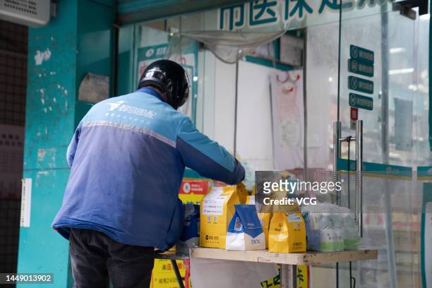 Deliveryman picks up customers' orders for medicines outsides a pharmacy on December 9, 2022 in Hangzhou, Zhejiang Province of China.