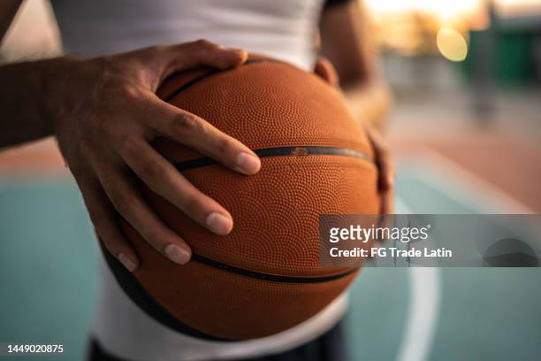 primer plano de un hombre con pelota de baloncesto en un campo de deportes - basket ball fotografías e imágenes de stock
