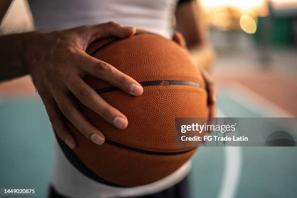 primo piano dell'uomo con la palla da basket al campo sportivo - basket ball foto e immagini stock