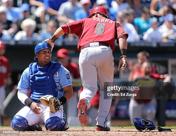 Gerardo Parra of the Arizona Diamondbacks pats Brayan Pena of the Kansas City Royals on the helmet after scoring in the eighth inning during an...