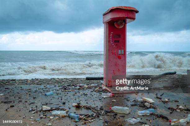 destroyed boxer strength tester  and storm sea waves on a coastline with plastic waste around - strength tester stock pictures, royalty-free photos & images