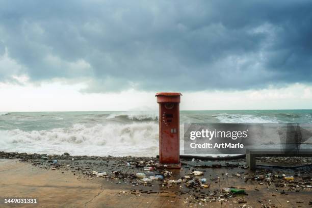 destroyed boxer strength tester  and storm sea waves on a coastline with plastic waste around - strength tester stock pictures, royalty-free photos & images