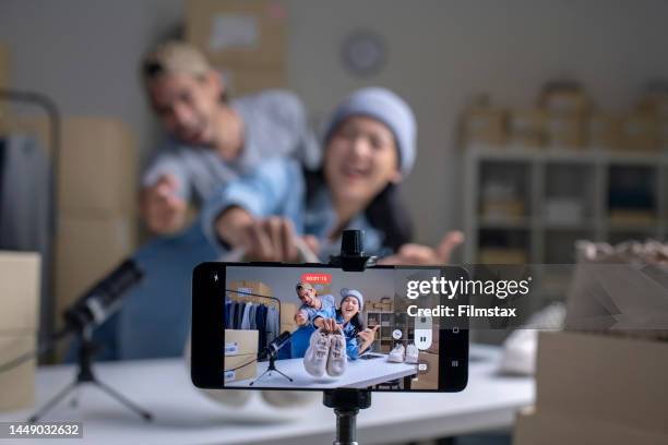 young asian couple e-commerce business owner talking and looking at camera reviewing product. - stream stock pictures, royalty-free photos & images