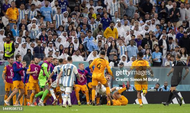 Lisandro Martinez of Argentina falls to the ground as he confronts Nathan Ake and Virgil van Dijk of The Netherlands following a dispute with the...