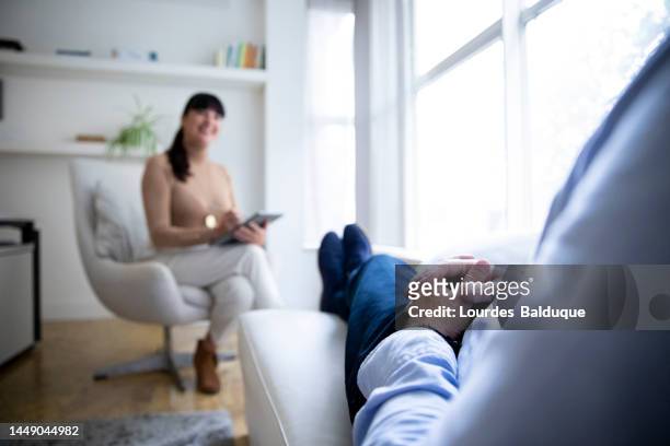psychological therapy, female psychologist consulting her client during a therapy session - alternative therapy fotografías e imágenes de stock