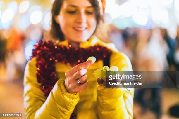 woman eating grape at new year's eve in spain - season 12 stockfoto's en -beelden