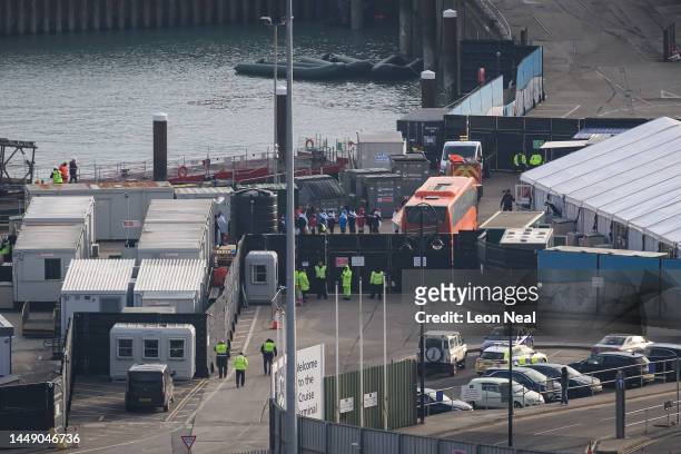 Line of migrants are seen boarding a coach after being rescued in the English Channel on December 14, 2022 in Dover, England. A major rescue...