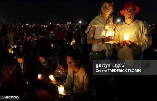 Pilgrims holding candles pray with Pope Benedict XVI during his prayer vigil at the Marienfeld near Kerpen part of the World Youth Day festival, 20...