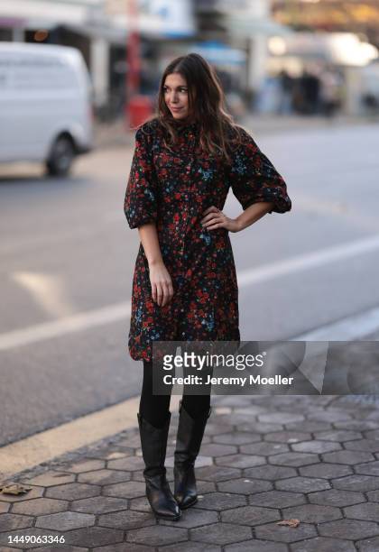 Anna Wolfers seen wearing a red and blue flower printed dress, black tights and cowboy boots on December 09, 2022 in Hamburg, Germany.