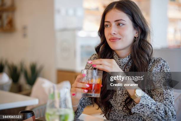 beautiful businesswoman sitting in a restaurant and having a drink on a meeting - bar drink establishment stock pictures, royalty-free photos & images