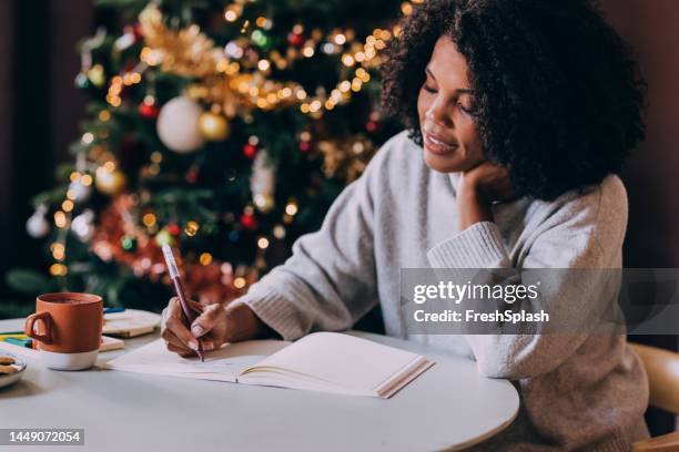 a happy beautiful woman relaxing at home near christmas tree - new years resolution stock pictures, royalty-free photos & images