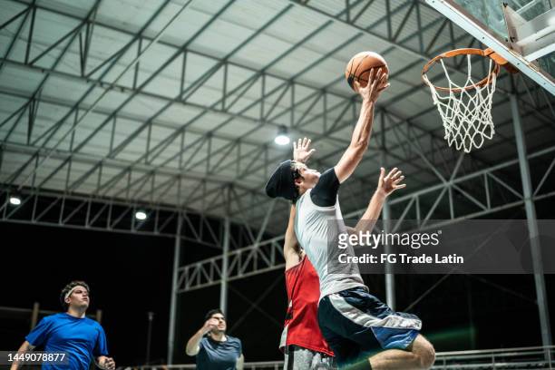 basketball player makes slam dunk at a basketball court - shooting baskets 個照片及圖片檔