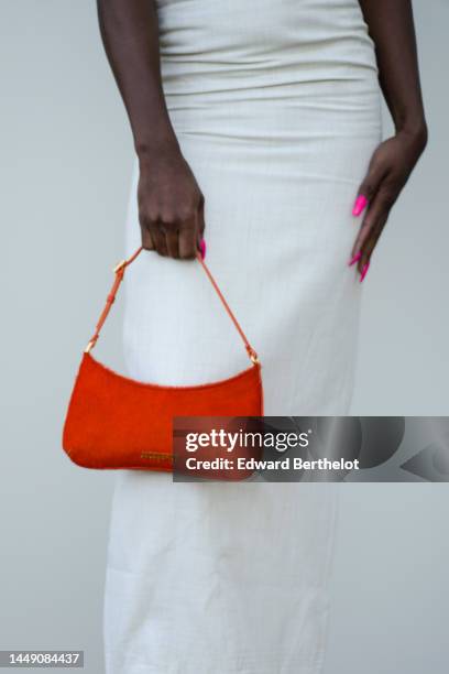 Symone wears a white latte shoulder-off / strappy chest / ruffled sleeves long tube dress, a neon red fur handbag from Jacquemus, outside the "Le...