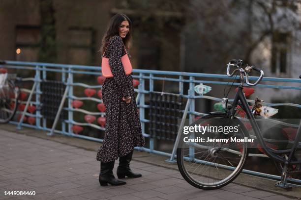 Anna Wolfers seen wearing a long flower patterned dress, an orange bag and black cowboy leather boots on December 09, 2022 in Hamburg, Germany.