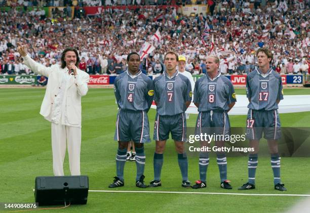 England players left to right, Paul Ince, David Platt, Paul Gascoigne and Steve McManaman join singer Paul Young in the singing of the national...