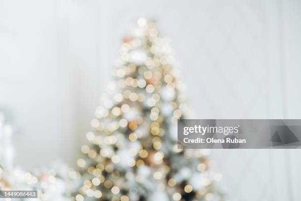blurred sparkling xmas tree against white wall. - christmas tree white background stock pictures, royalty-free photos & images