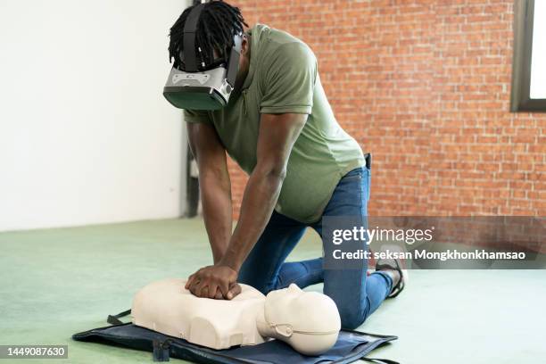 young woman using virtual reality headset for online cpr training. - simulation dummy stock pictures, royalty-free photos & images