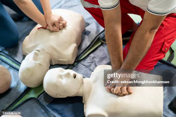 hands of a trainee doing chest compression during defibrillator cpr training. - wiederbelebung stock-fotos und bilder